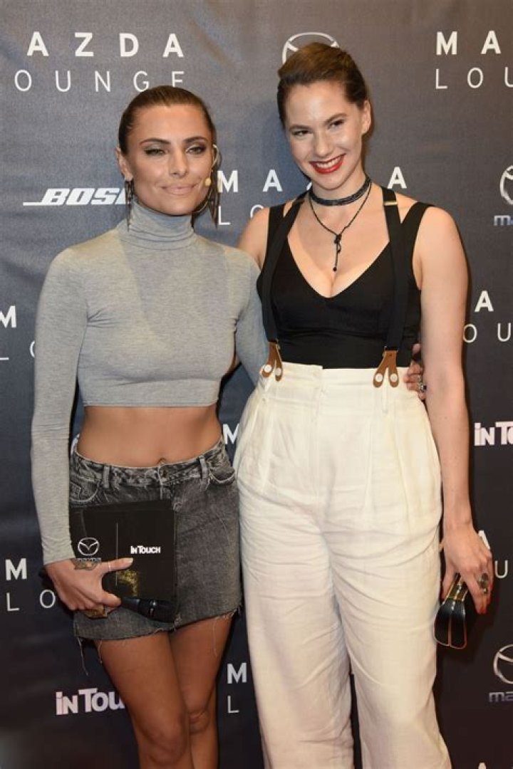 Emma Kathleen Ferrer wearing white pants with braces at the Mazda and