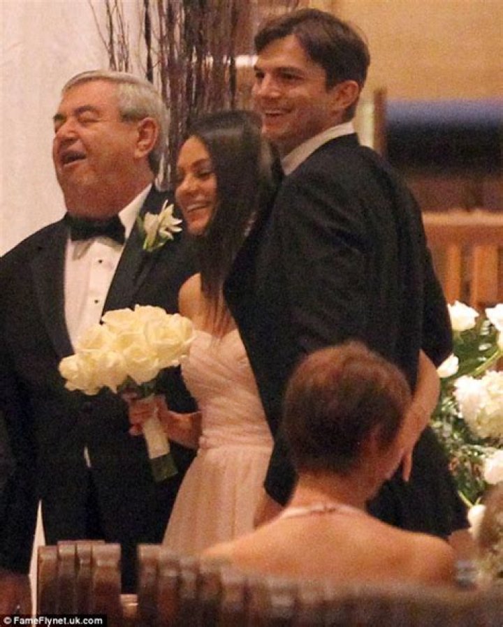 Mila Kunis hugs her father as Ashton Kutcher looks on at her brother's