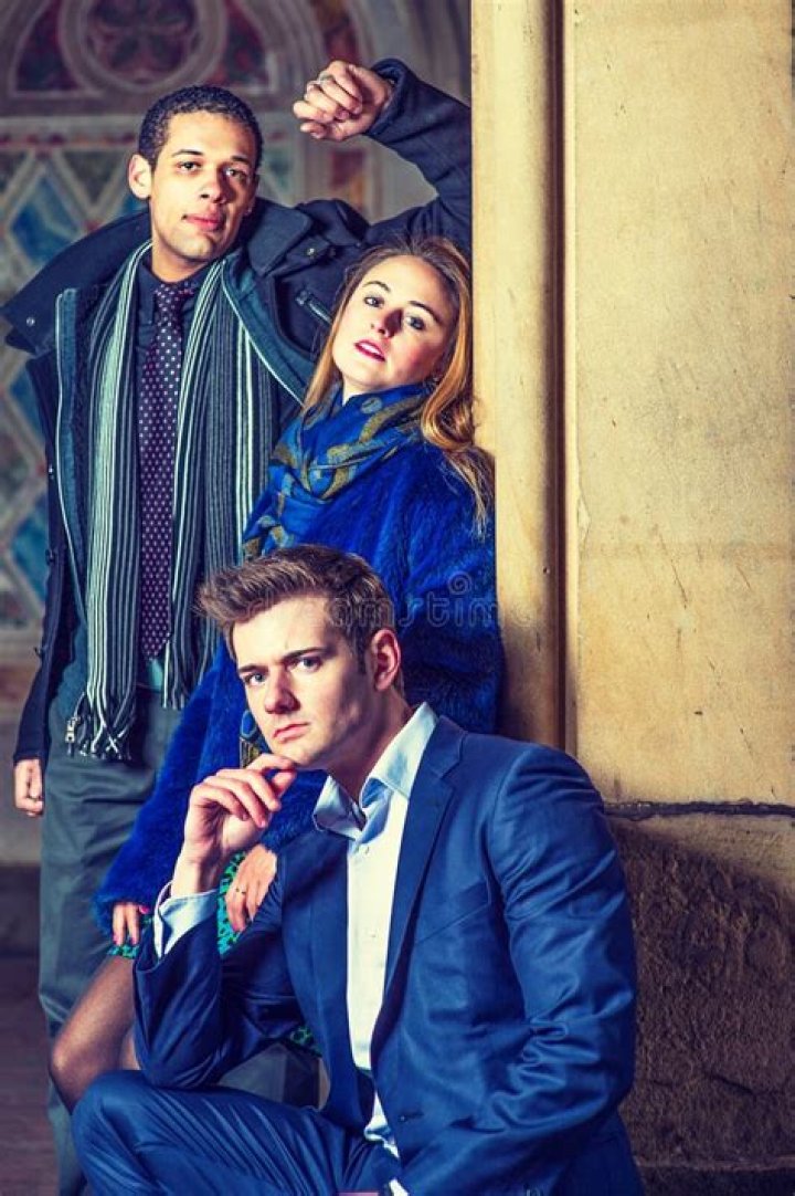 two men and one woman are posing for pictures